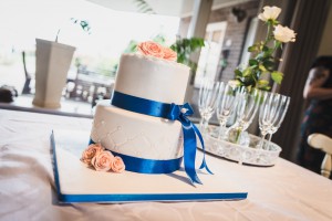 Bruidstaarten - Witte stapel met blauw satijnband en zalmkleurige roosjes