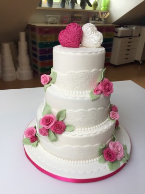 Bruidstaarten - Witte stapel met roze roosjes en 3D harten in roze en wit Bruidstaarten - Witte stapel met roze roosjes en 3D harten in roze en wit
