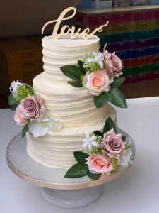 Bruidstaarten - Cremetaart met zijden bloemen en LOVE taarttopper